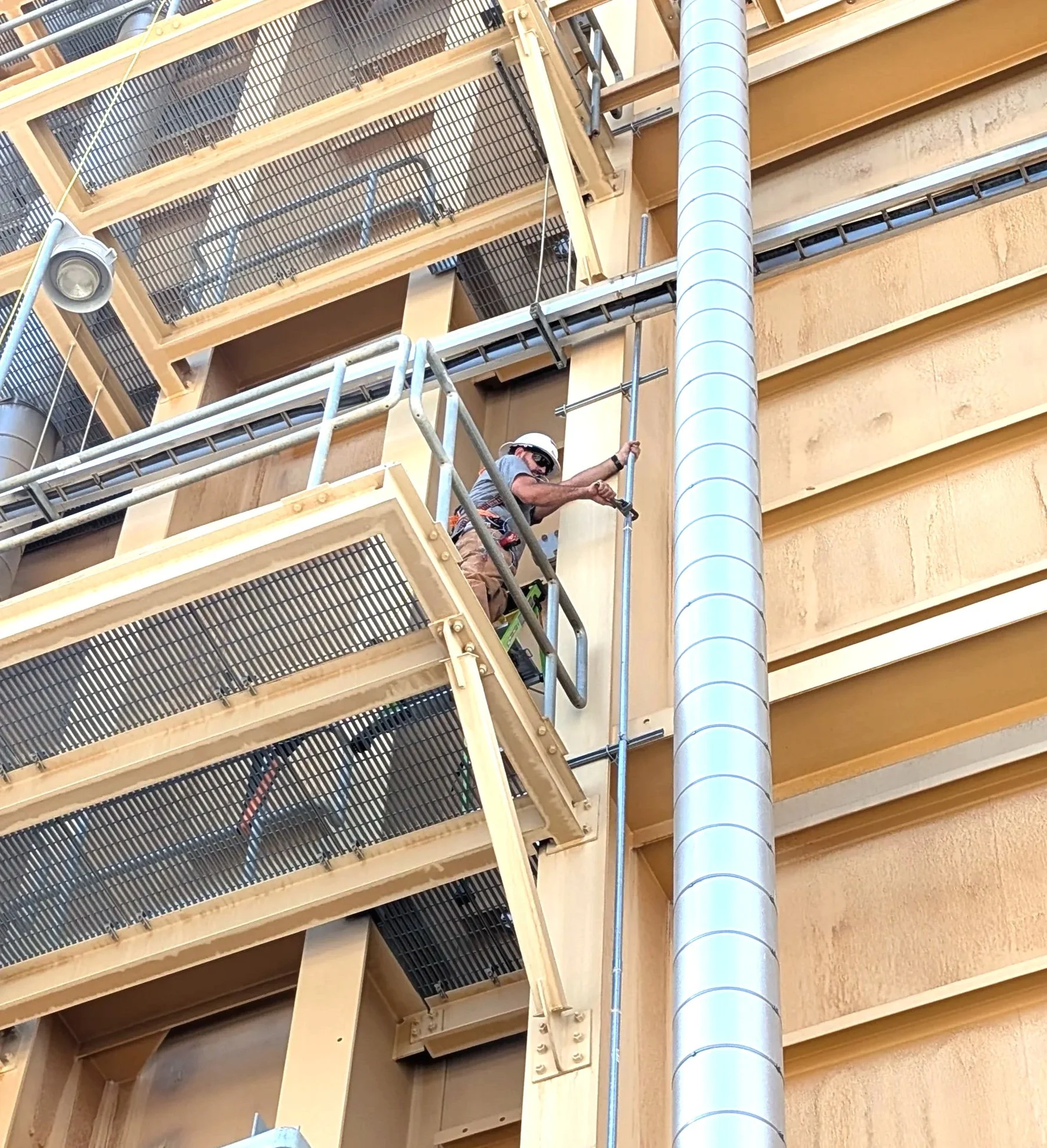 CONTRACTOR RUNNING RIGID CONDUIT TO TOP OF HRSG