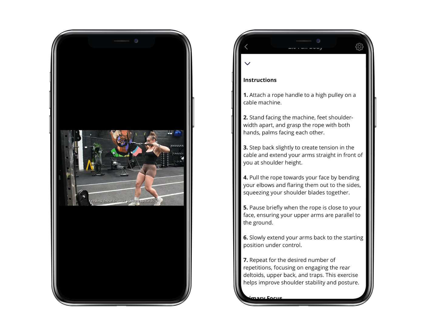 A woman in a gym performing a resistance exercise with a rope, facing a screen displaying instructions for the exercise.