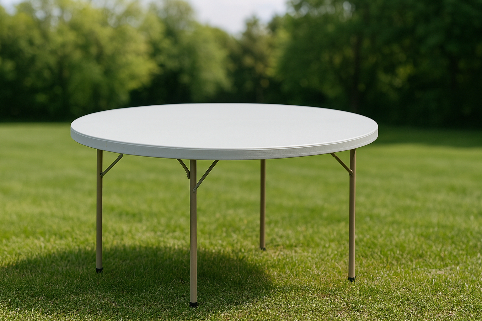 Folded white plastic table outdoors on green grass with trees in the background