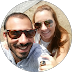 A couple smiling outdoors, taking a selfie on a sunny day