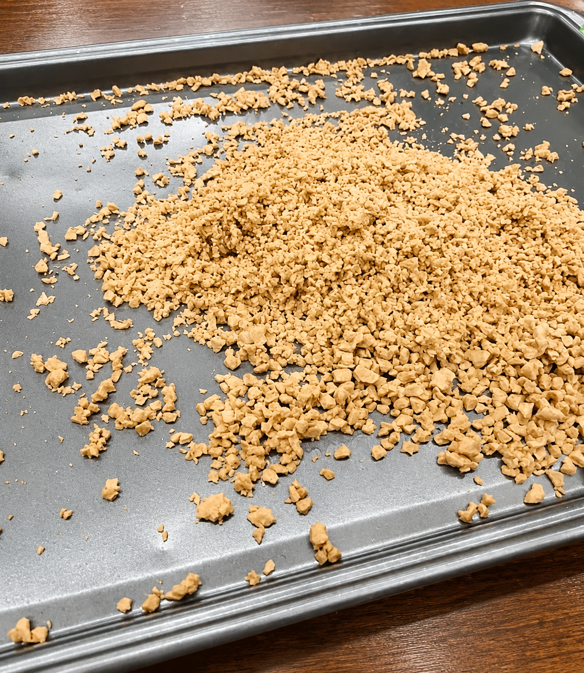 Crumbled cooked sausage on a baking sheet.