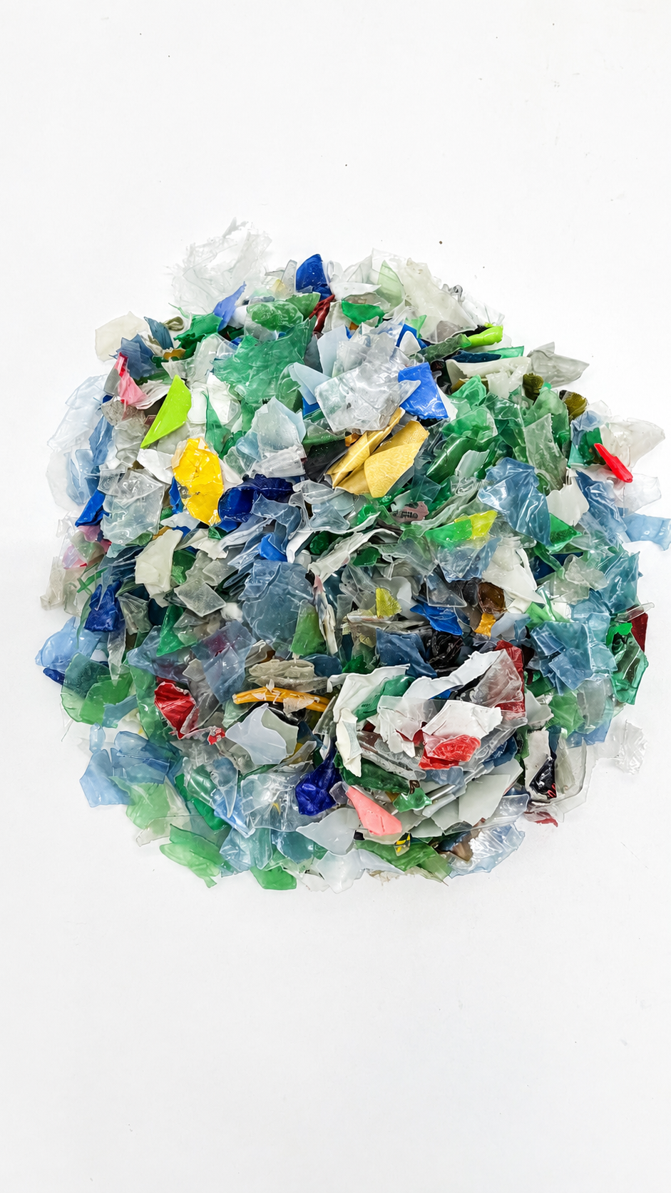 A pile of crushed and fragmented colorful plastic debris on a white background.