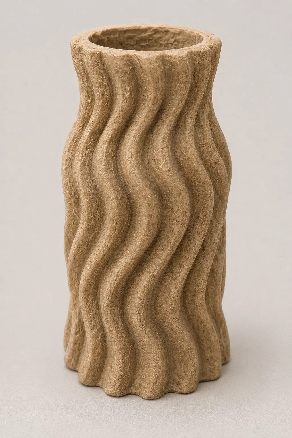 A beige, textured ceramic vase with a wavy, twisted design.