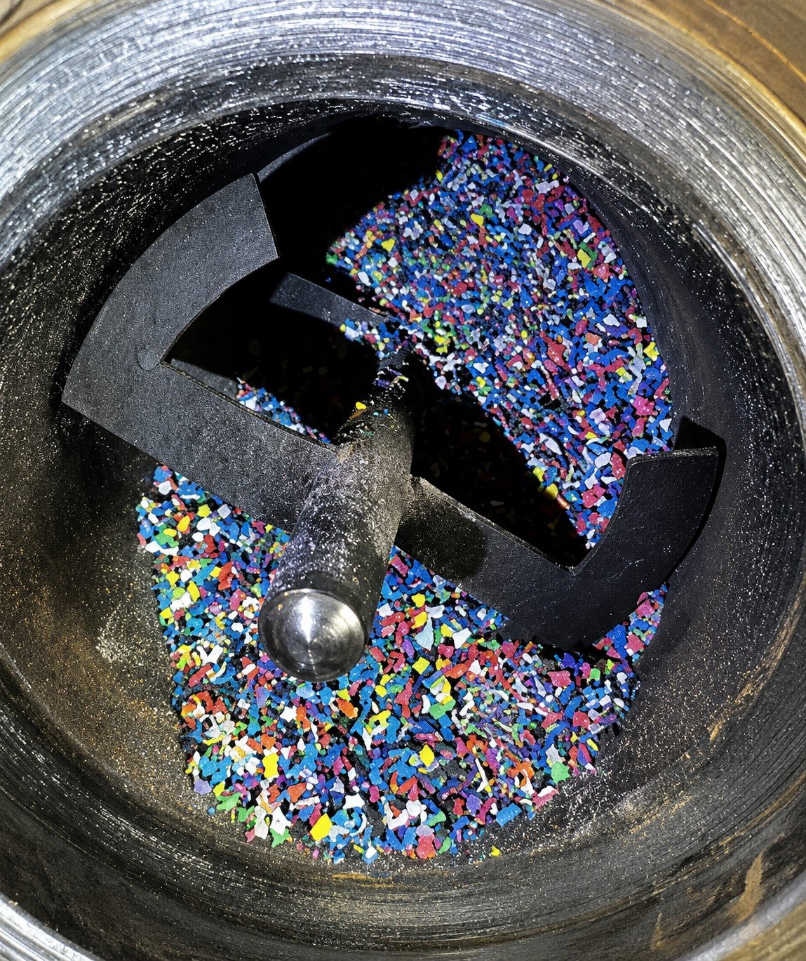 A close-up view of a metal blender with multicolored sprinkles inside, ready to be processed.