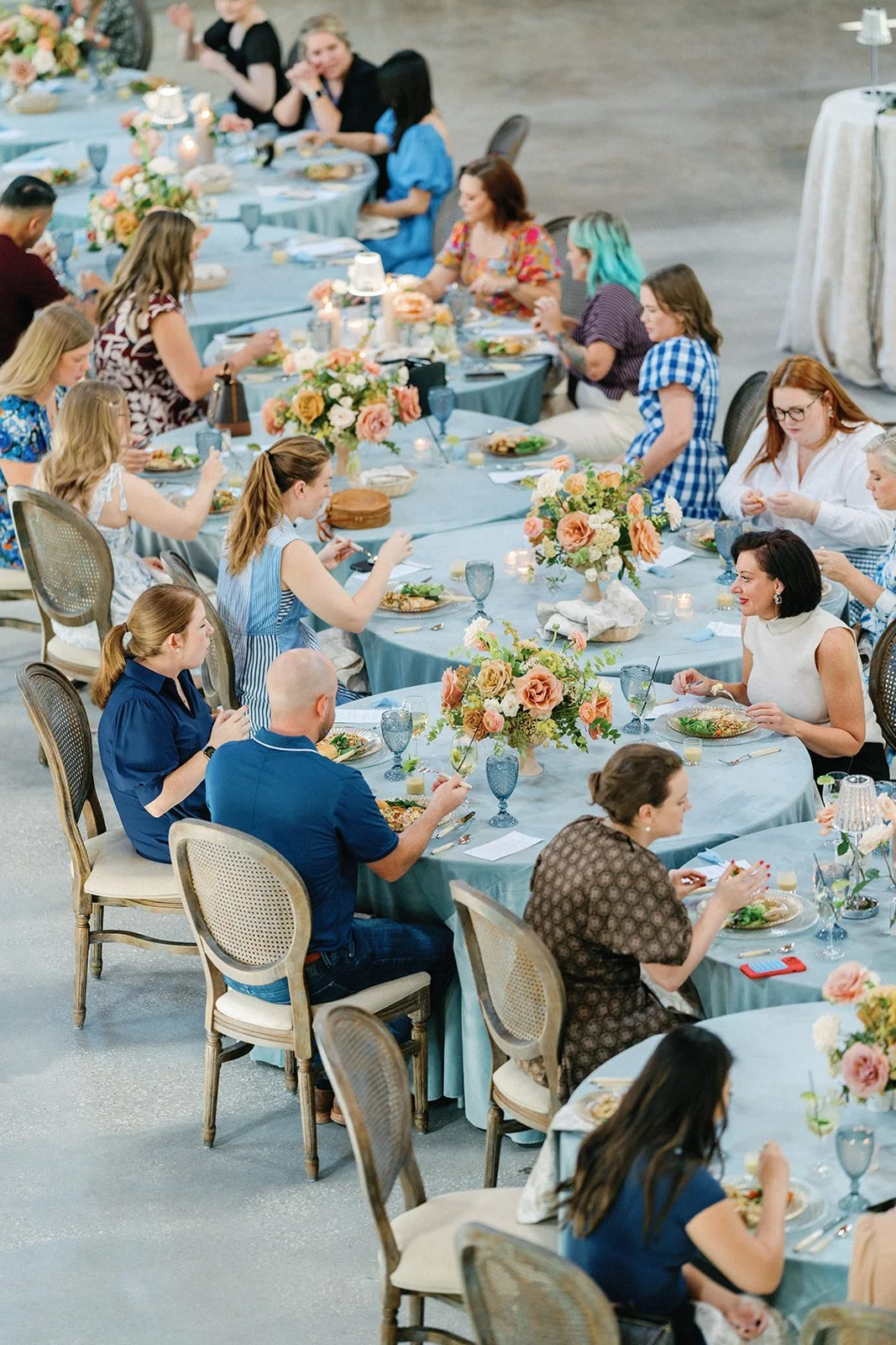 group of guests at tables with florals
