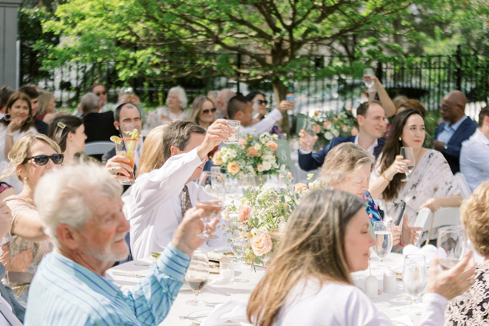 cheers outside at a venue with guests