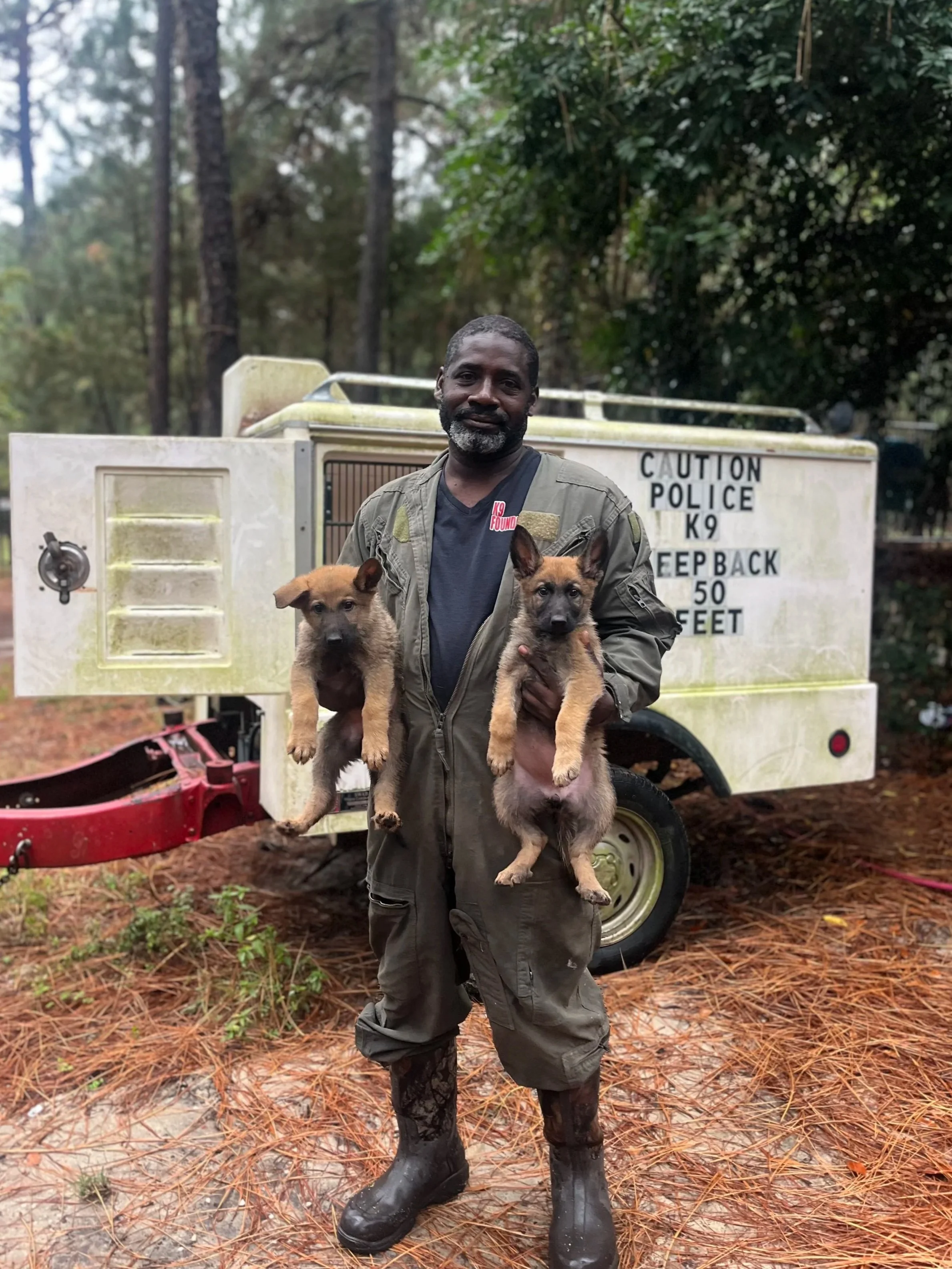 Kevin Bain, dog trainer, posing with Grim De Nonpareil and Sailor De Nonpareil