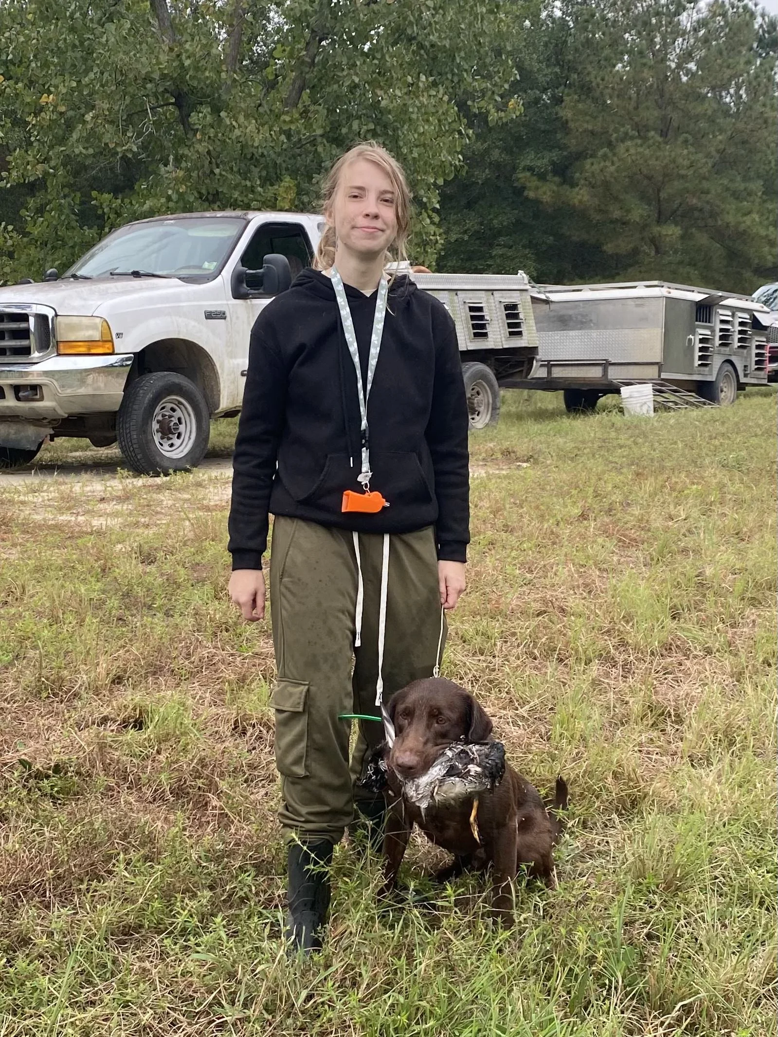 Blaze Parker Training a Bird Dog for Field Trials. The Dog is a Labrador Retriever with a Duck in his mouth.