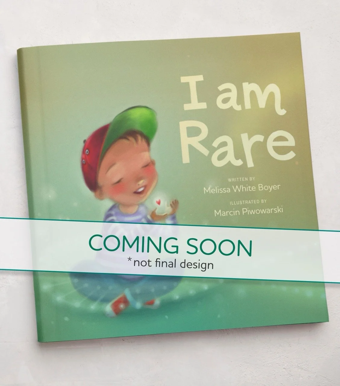 Cover of a children's book titled 'I am Rare' with an illustration of a smiling child wearing a red and green cap, holding a small heart, and wearing a striped shirt, against a light green background. The book is marked 'COMING SOON' with a note that it is not the final design.