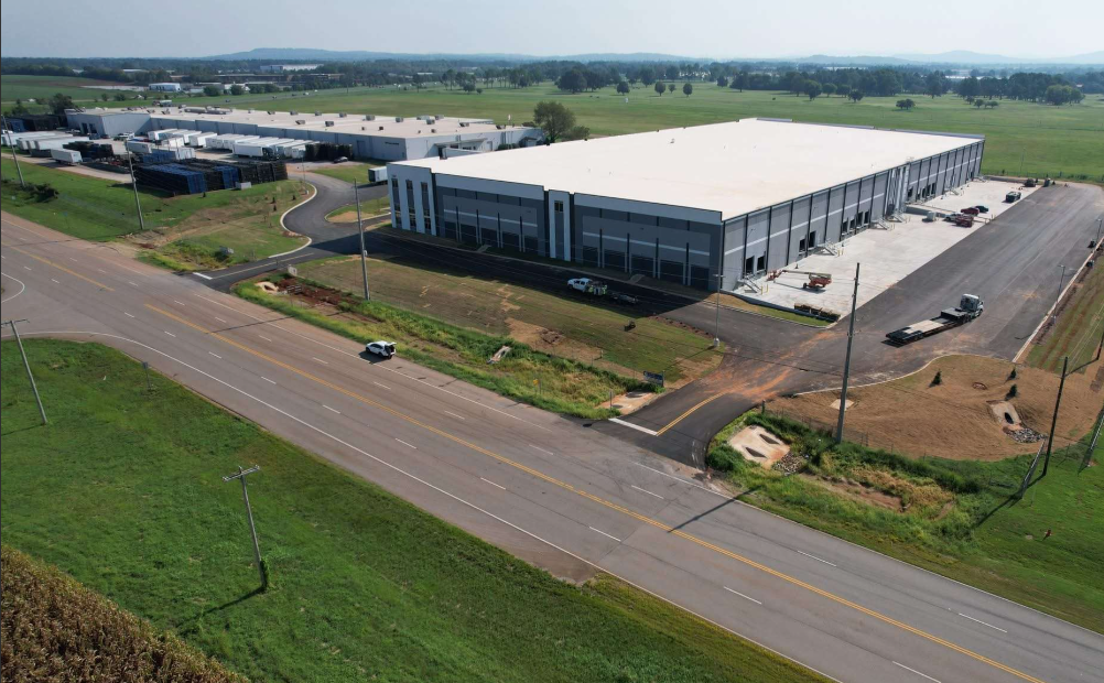 Image of a newly built warehouse surrounded by land and trees
