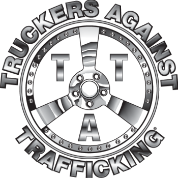 A circular emblem with the words "Trucker's Against Trafficking" around the perimeter, featuring the letters T, T, A in the center, and a depiction of a steering wheel.