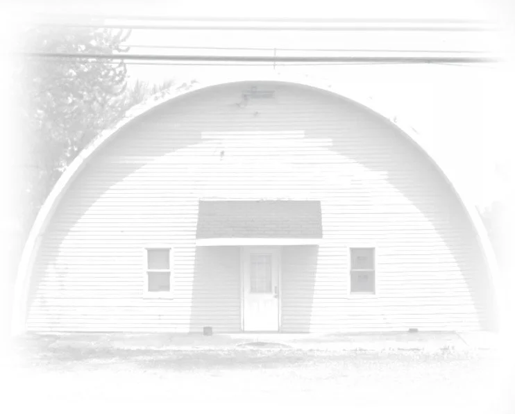 A black and white photo of an old quonset hut in 1986