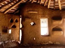 Interior of a traditional mud hut with small windows and built-in shelves