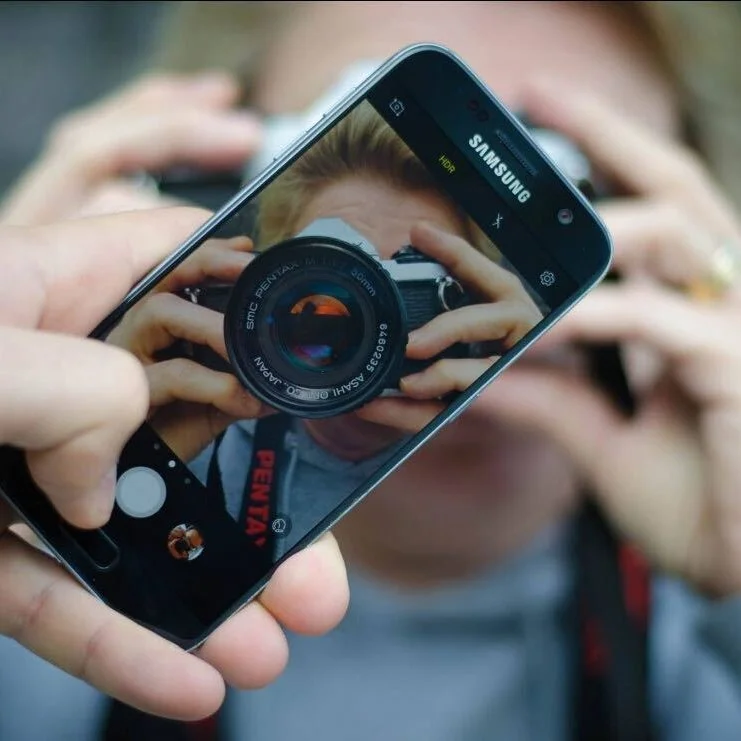 Image of phone taking photo of photographer