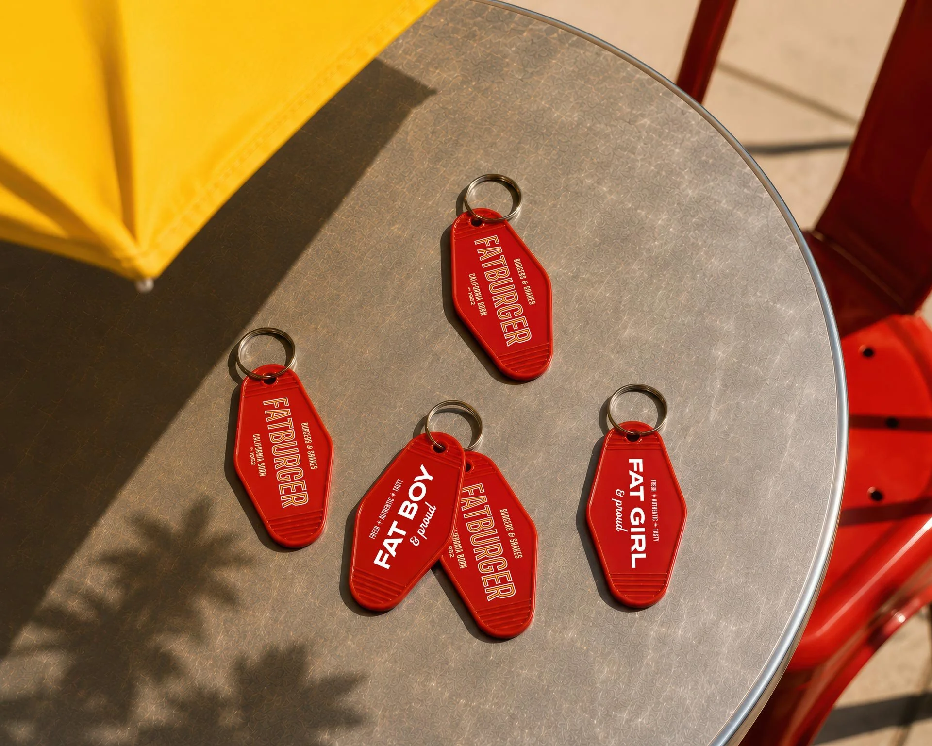 FATBURGER plastic keychains laying on an outdoor table