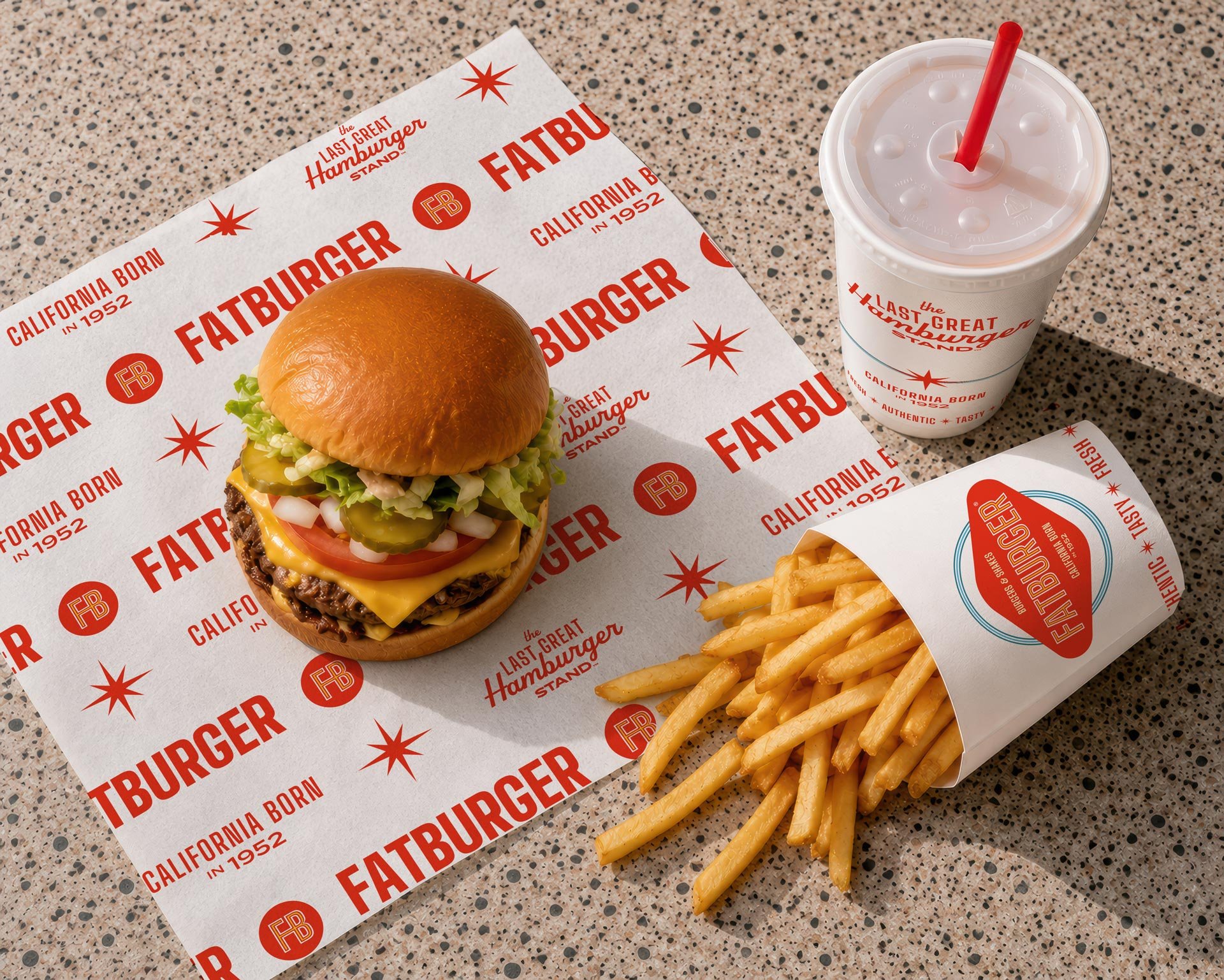 Overhead image of a FATBURGER burger and fries with newly redesigned packaging