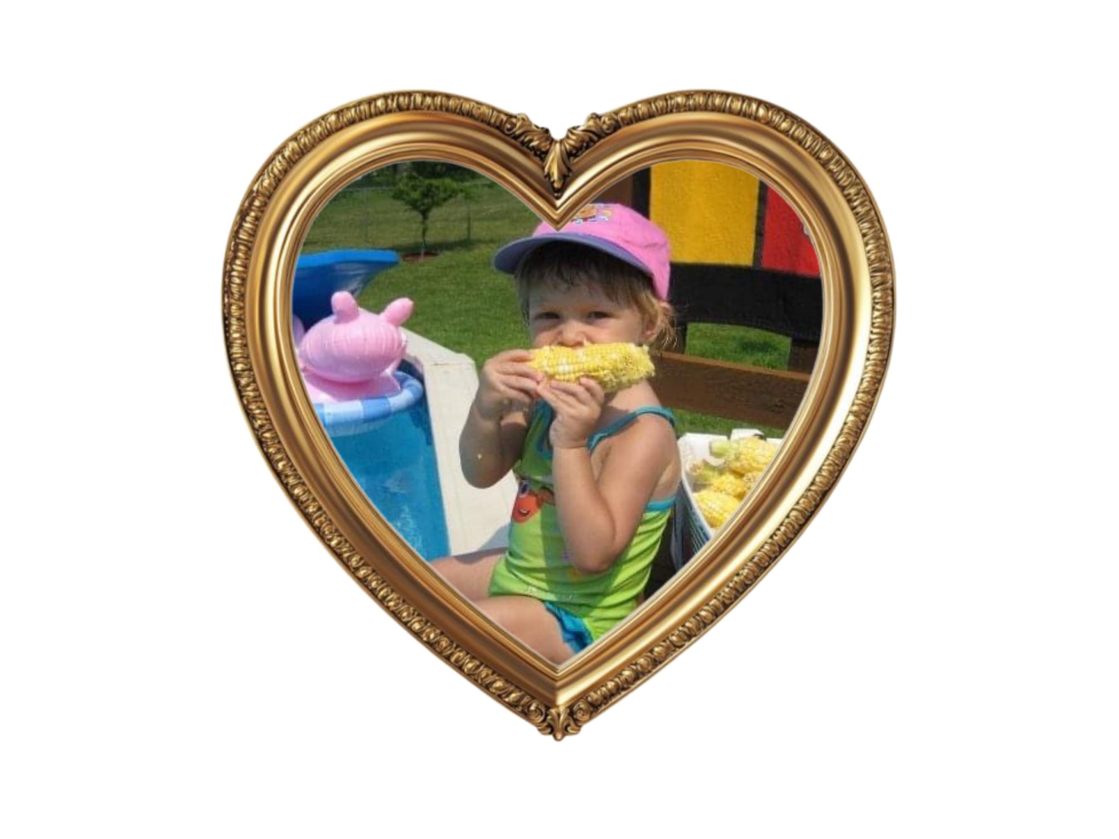 A young girl with a pink cap eating corn on the cob outdoors at a sunny day, framed within a golden heart-shaped picture frame.