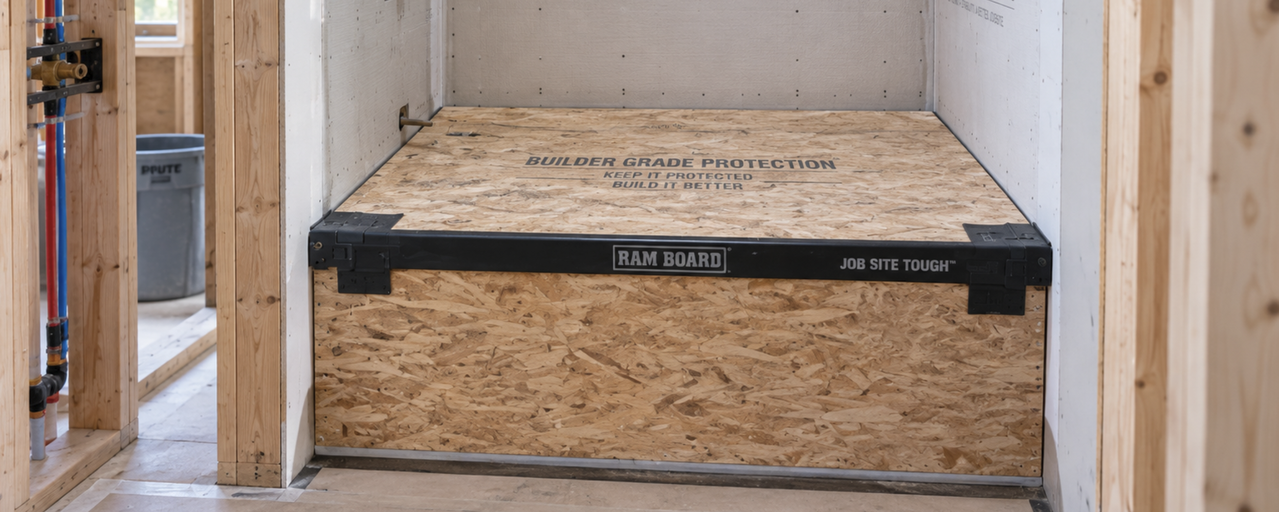 Protected shower area in a custom home under construction, with plywood covering the shower base to prevent damage during the building process in Northwest Florida.