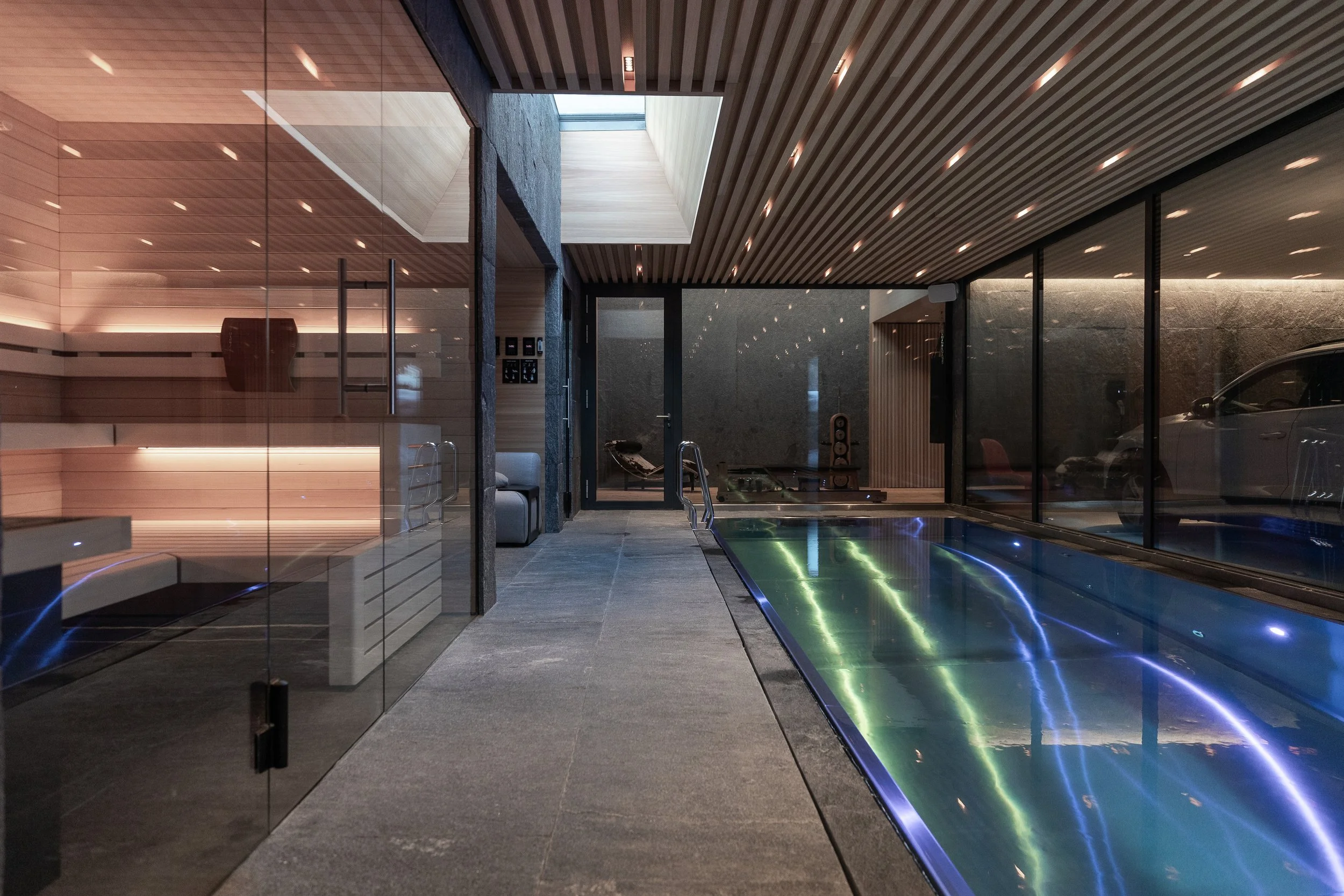 10m Indoor swimming pool with with counter stream, adjacent to a sauna, steam room, and cold plunge.