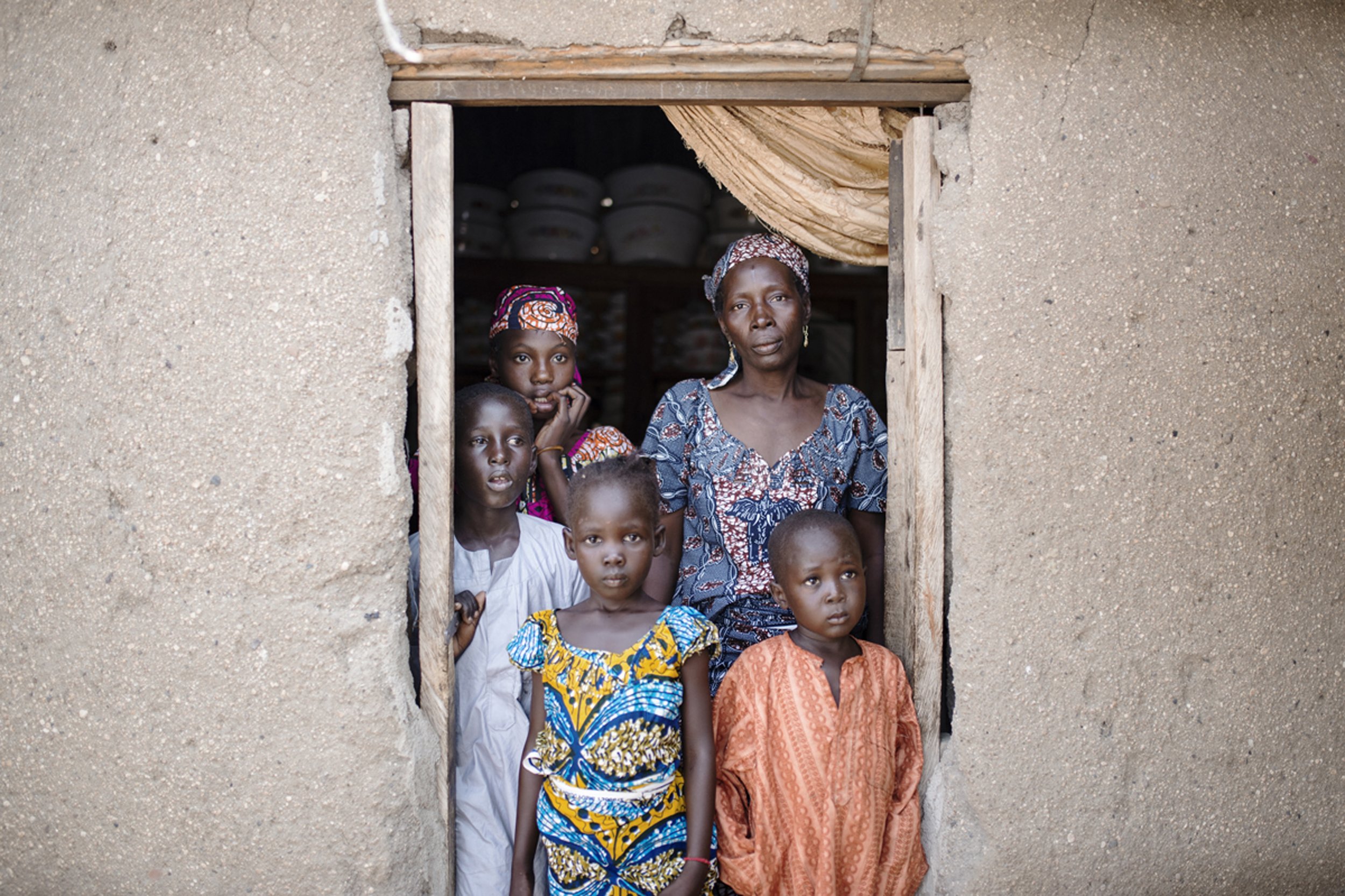 Fadimatou och hennes syskon med sin fostermamma, Fadi, som stod och sålde kol längs vägen när barnen gråtande kom och bad om vatten för två år sedan.