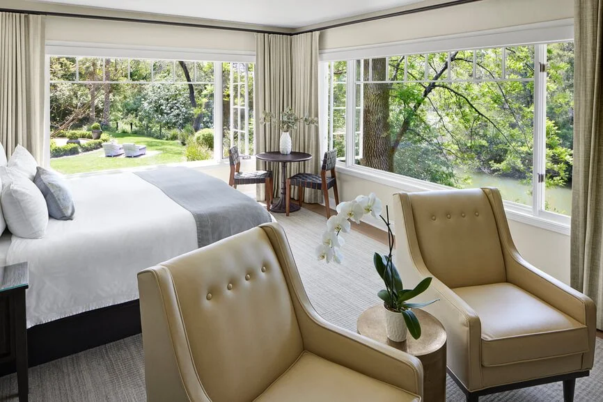 Beige wall width traversing drapes with black track hardware