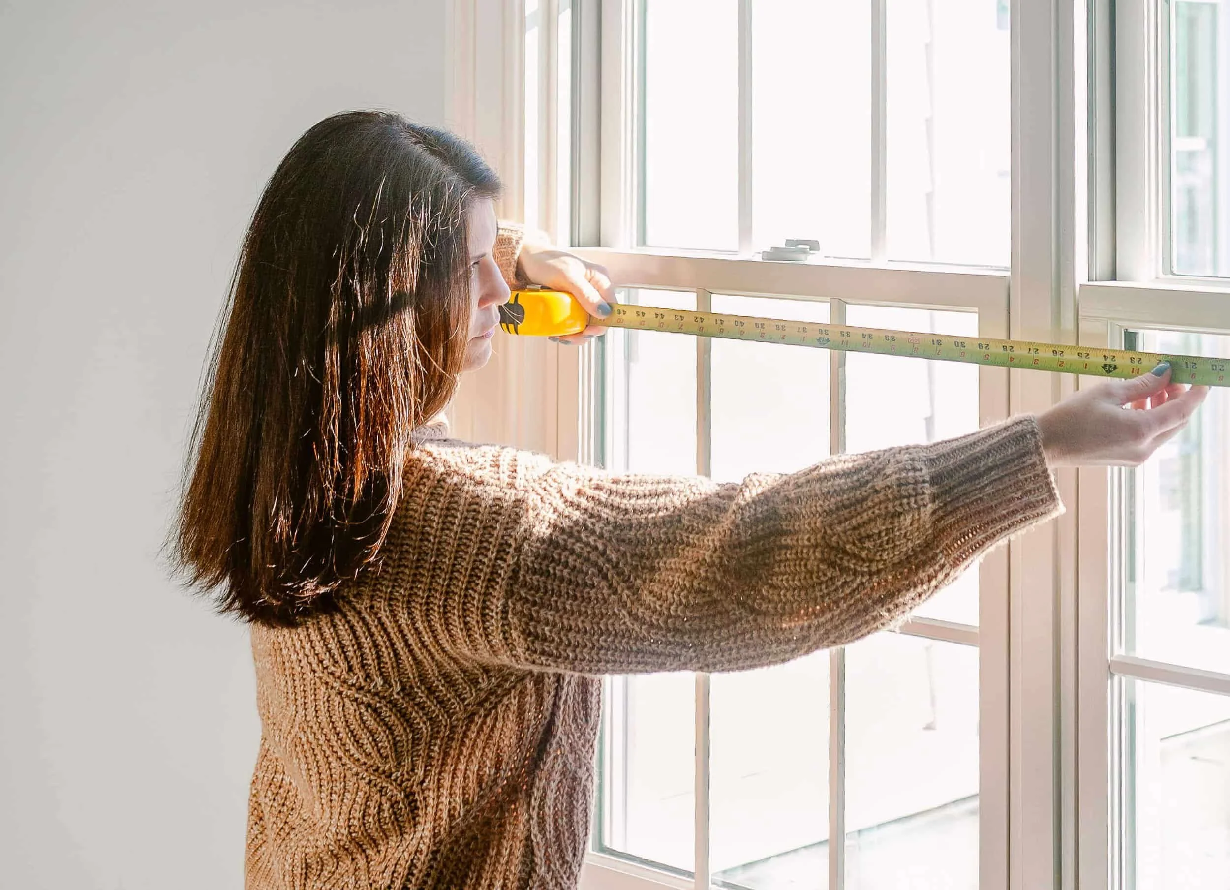 In home custom window treatment design consultation where window being measured by an expert