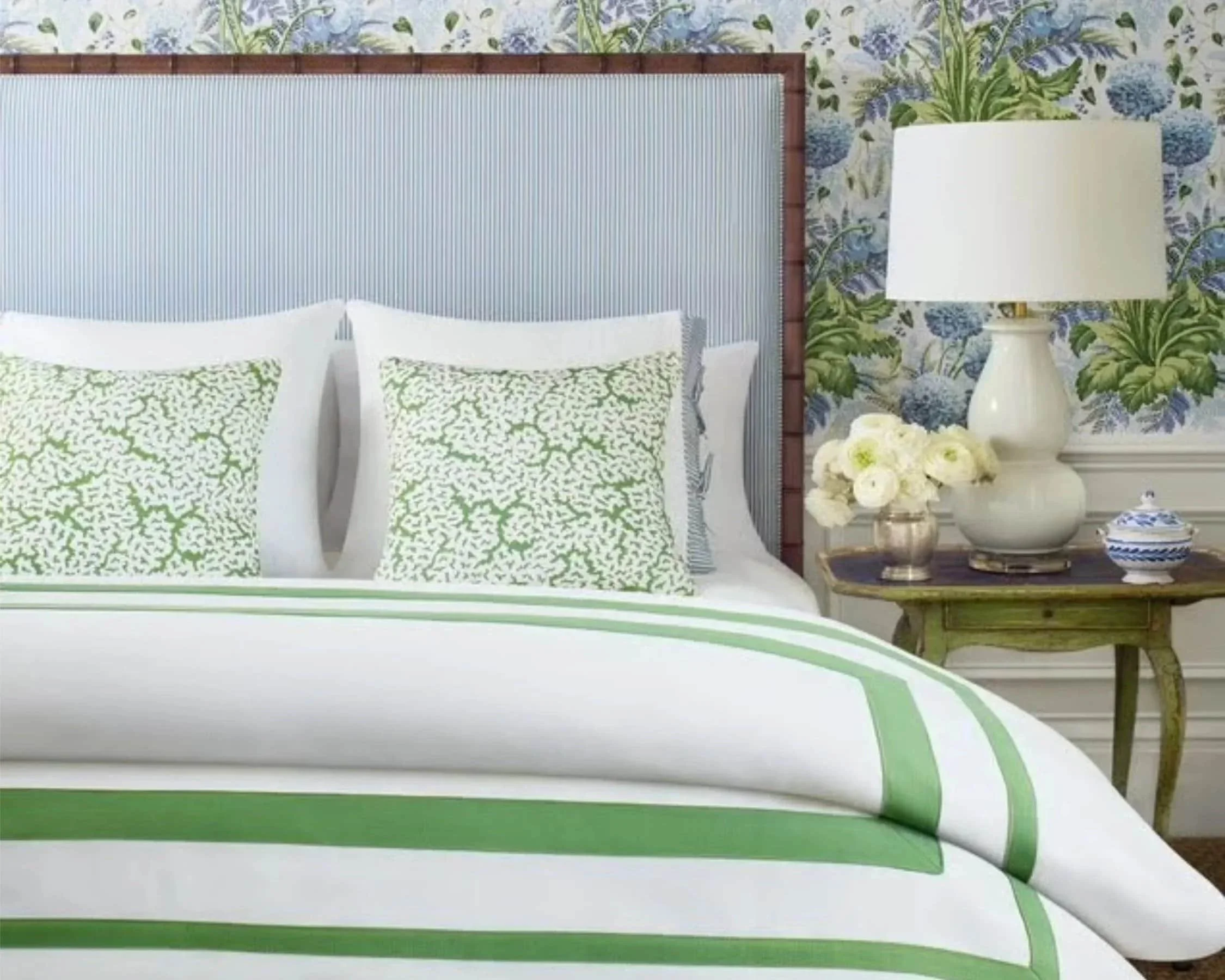Custom pillows, bedding, and wallpaper with coordinating patterns in a primary bedroom