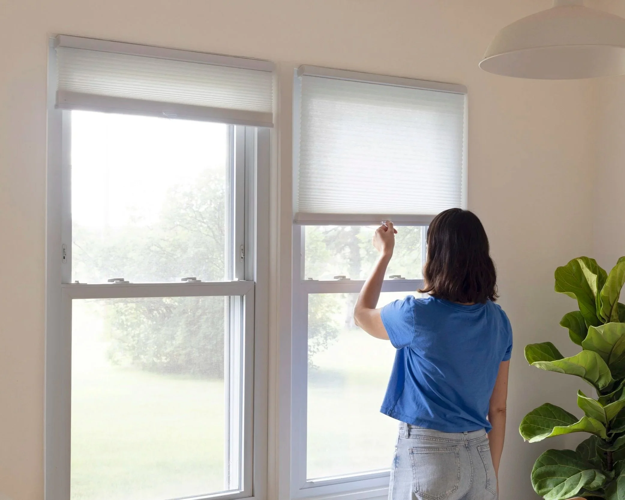 Woman-operating-cellular-shades