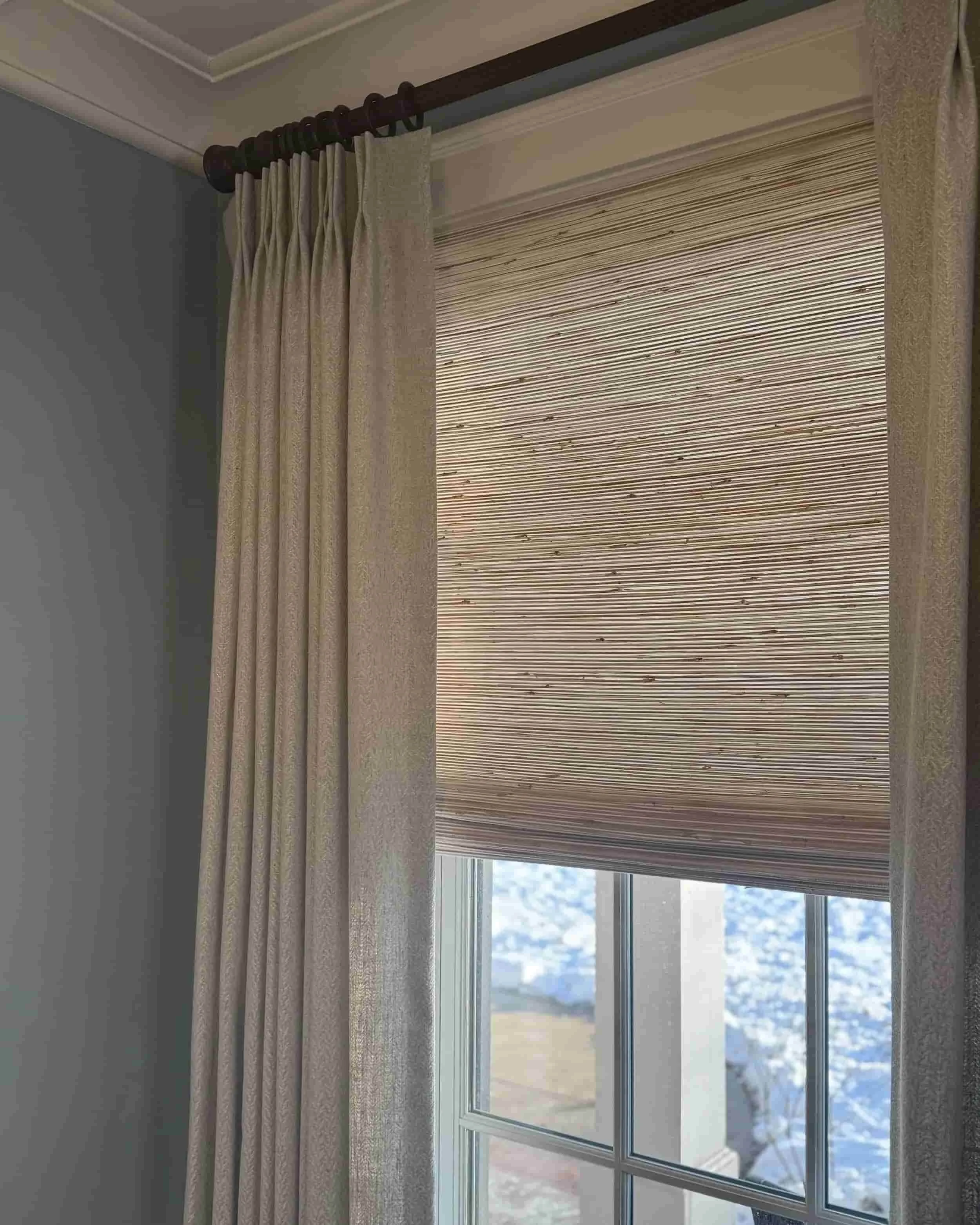 Custom drapery panels over woven wood shades