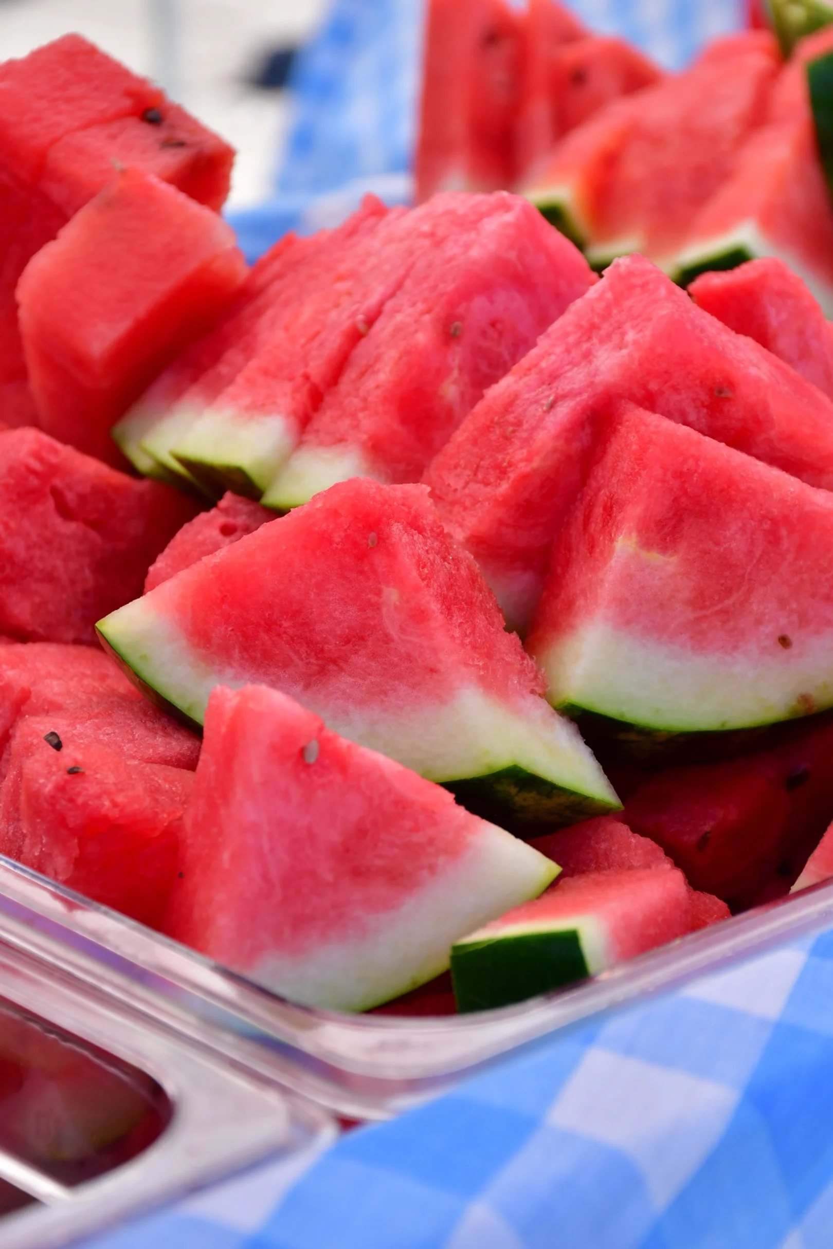 Close-up of freshly cut watermelon slices arranged in a clear container.
