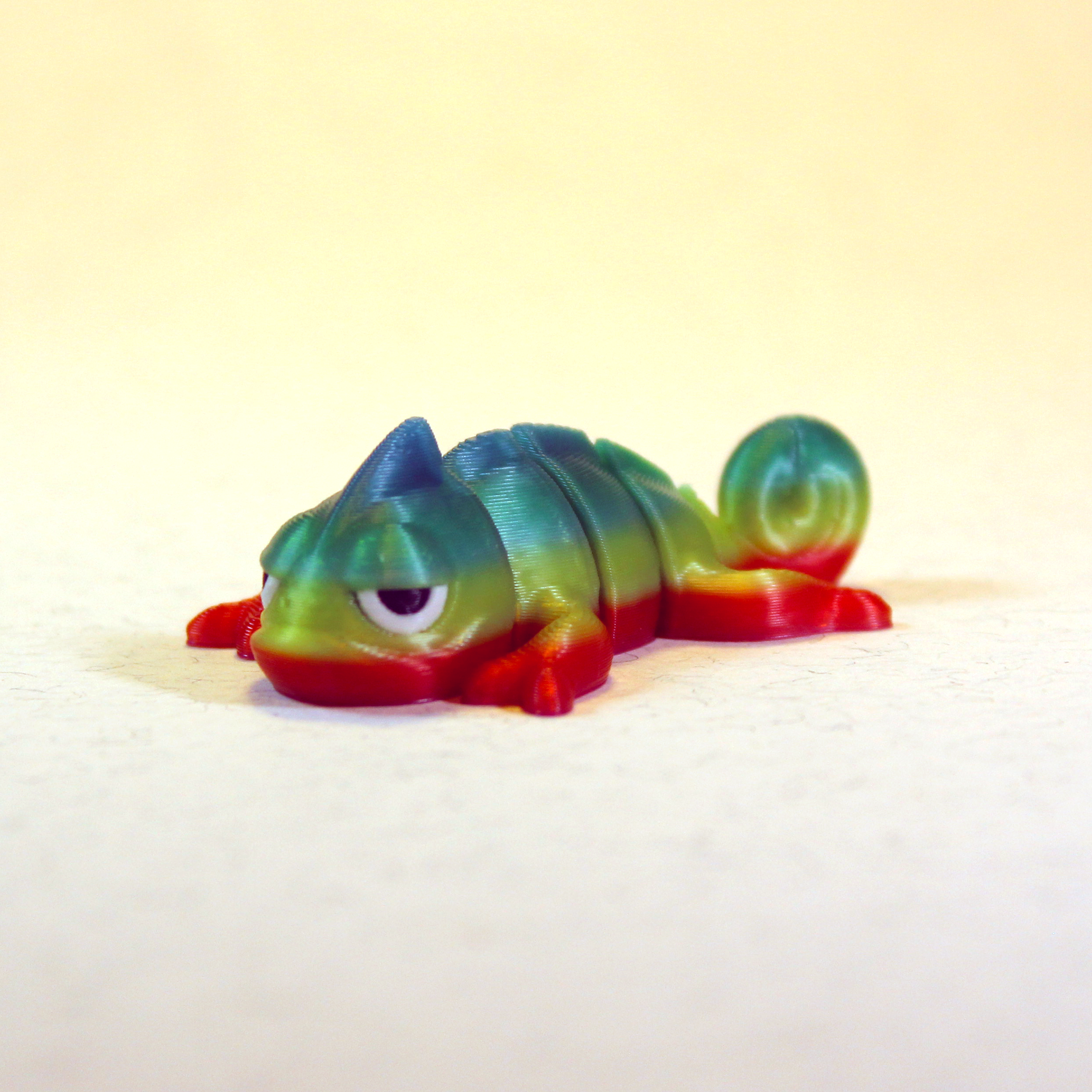 Rainbow-coloured chameleon Zigglie with a mischievous smirk.