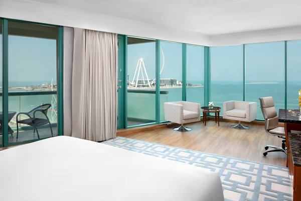 hilton dubai jumeirah king guestroom with water and ferris wheel views from floor to ceiling windows