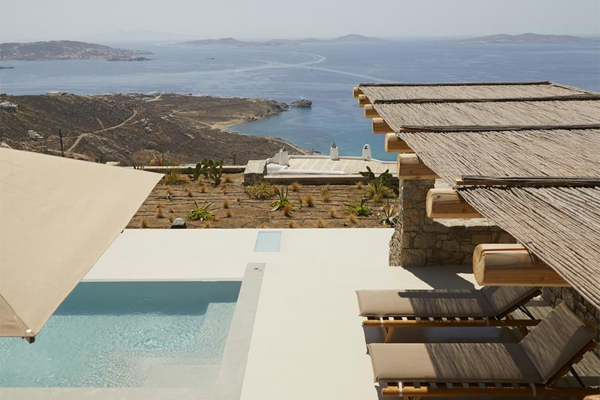 pool with cabana and lounge chairs and sea view in background