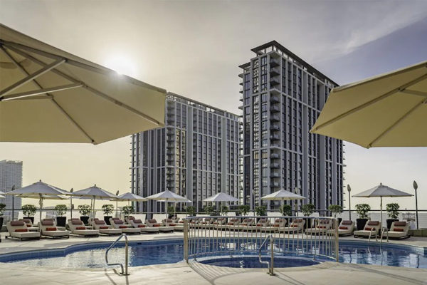 towers rotana pool with lounge chairs and umbrellas surrounding the pool and the hotel tower exteriors in the background