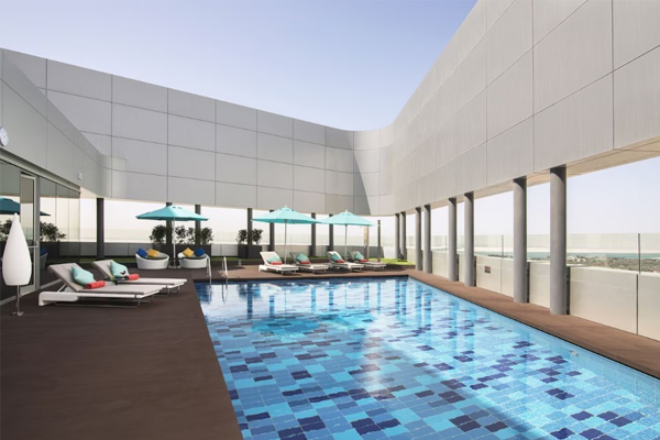 rooftop pool at pearl rotana capital centre with lounge chairs and umbrellas surrounding the pool