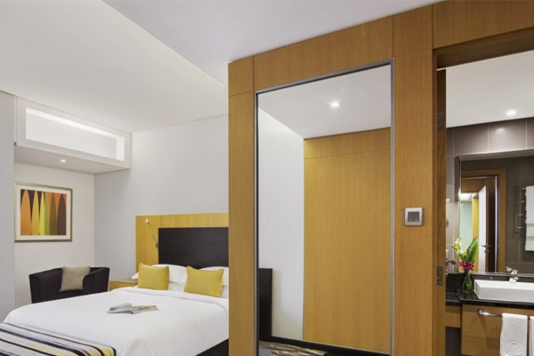guestroom at hala arjaan by rotana with one bed and side view of bathroom