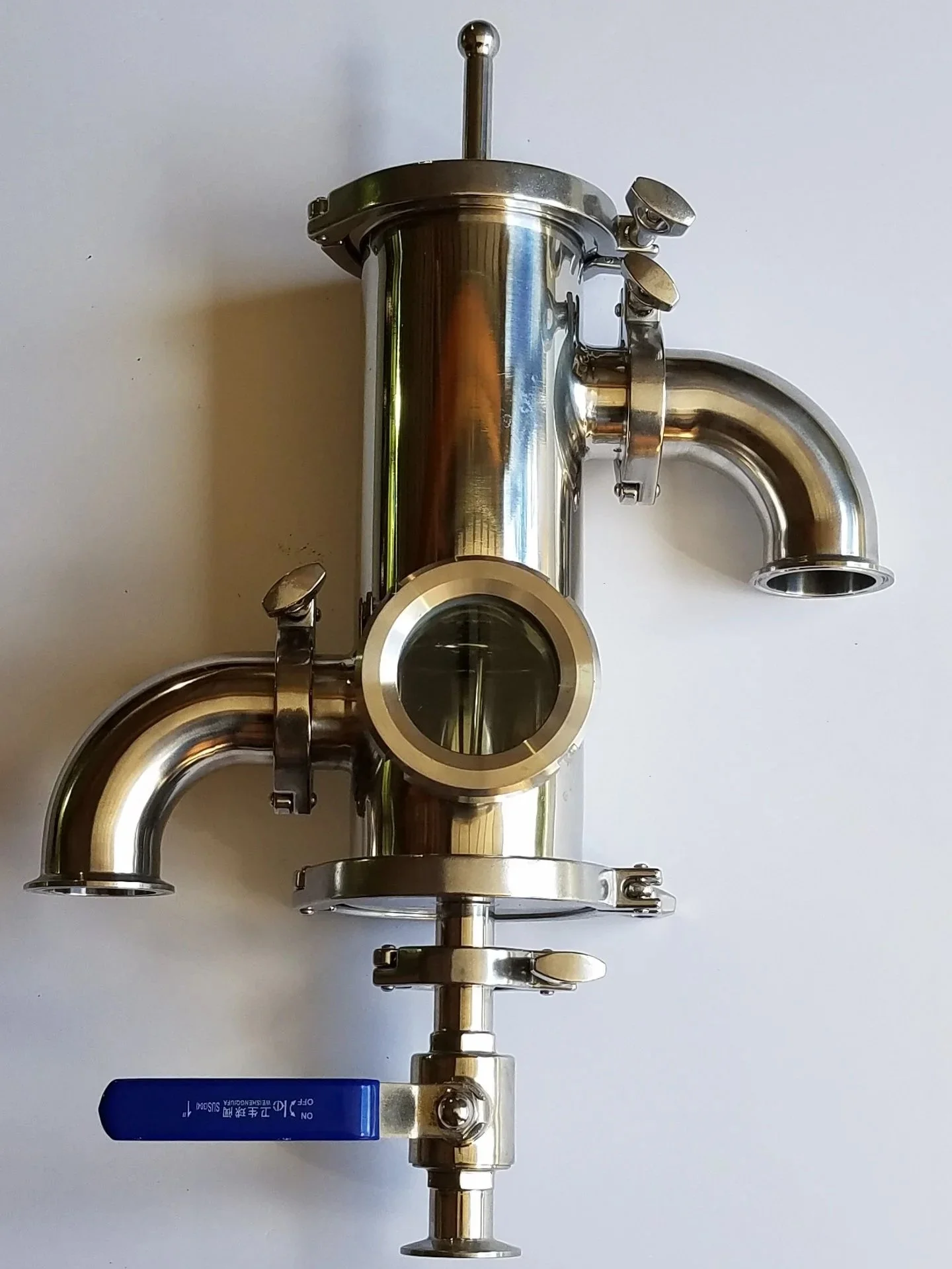 A metal juice extractor with a cylindrical body, a black clamp, and a small mesh filter on a white background.