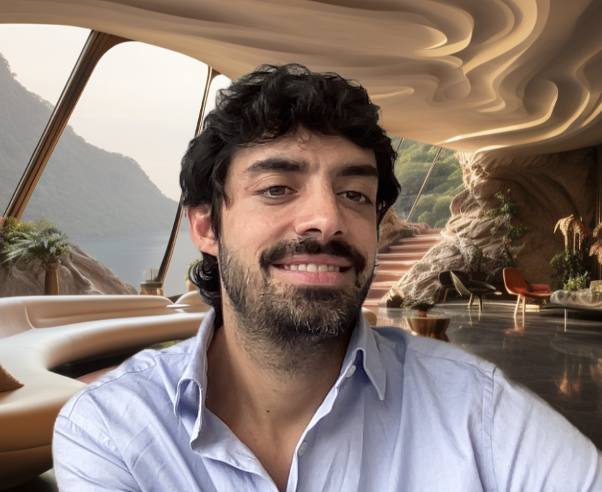 A man with dark curly hair and a beard smiling, wearing a light blue button-up shirt, in a modern, nature-inspired interior, with large windows overlooking a lake and mountains, decorated with rocks, plants, and contemporary furniture - AI generated