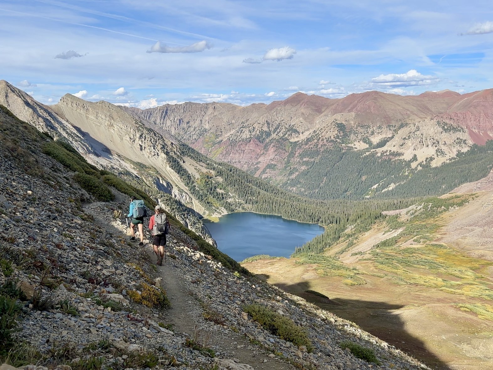 Two backpackers descending from Trail Rider Pass to Snowmass Lake