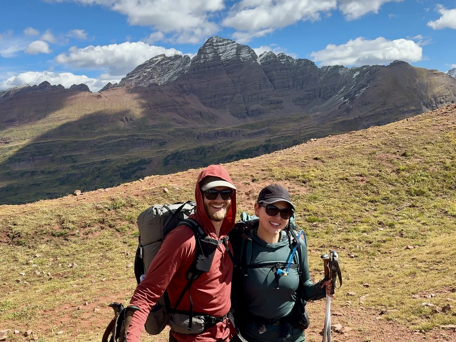 Two backpackers on top of Frigid Air Pass with the Maroon Bells mountains behind them.