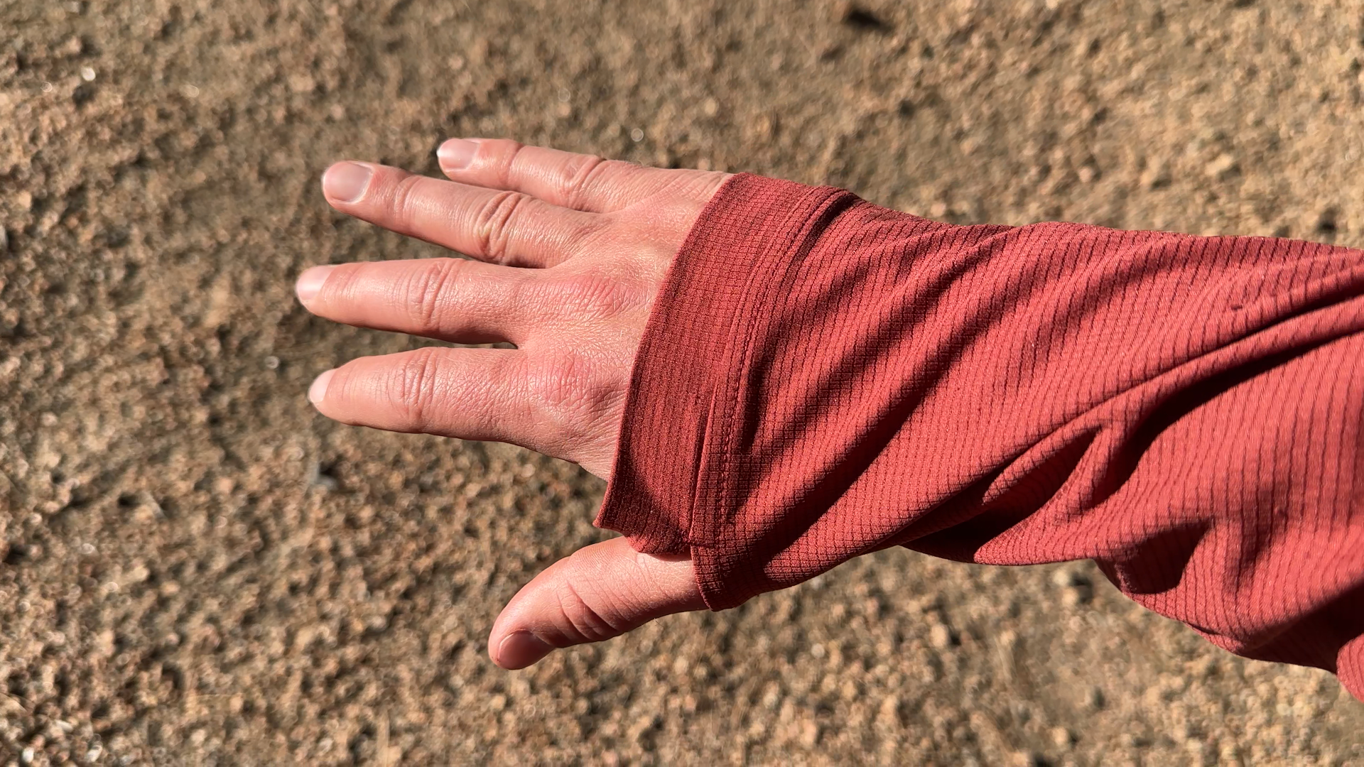 Hiker with the Ketl Mountain Nofry Sun Hoodie on and his thumbs using the thumb holes