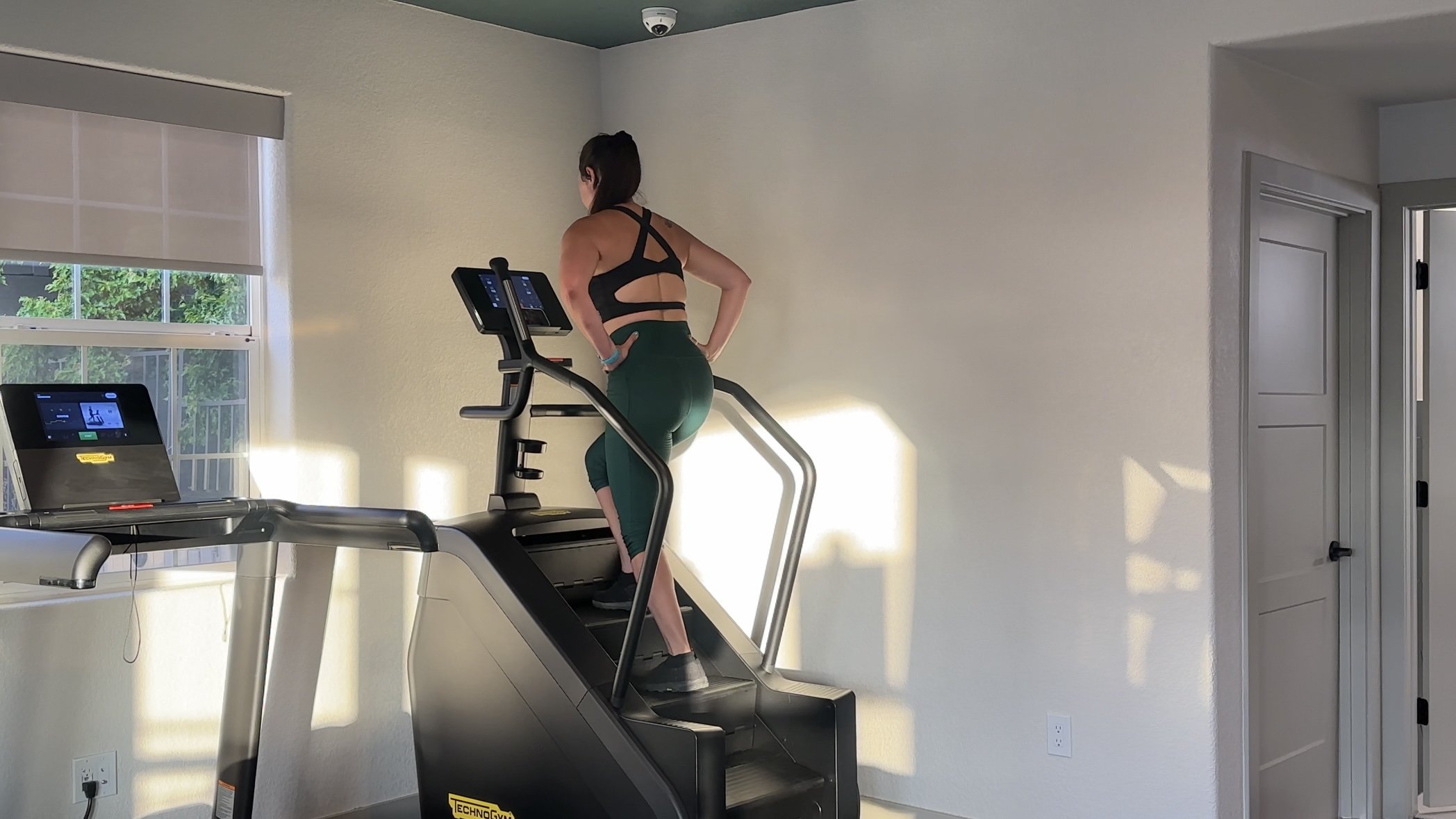Beautiful female at the gym using the stair climber master