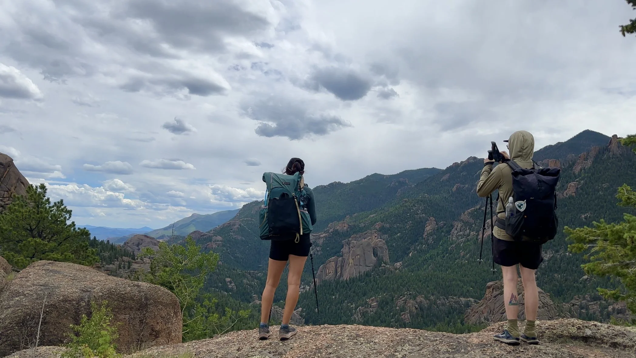 Two hikers looking at a beautiful scenic mountain view