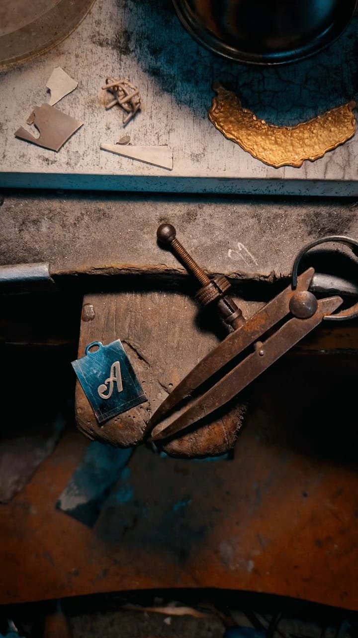 Paesaggio con lago di montagna, colline verdi, e montagne rocciose con cielo nuvoloso.