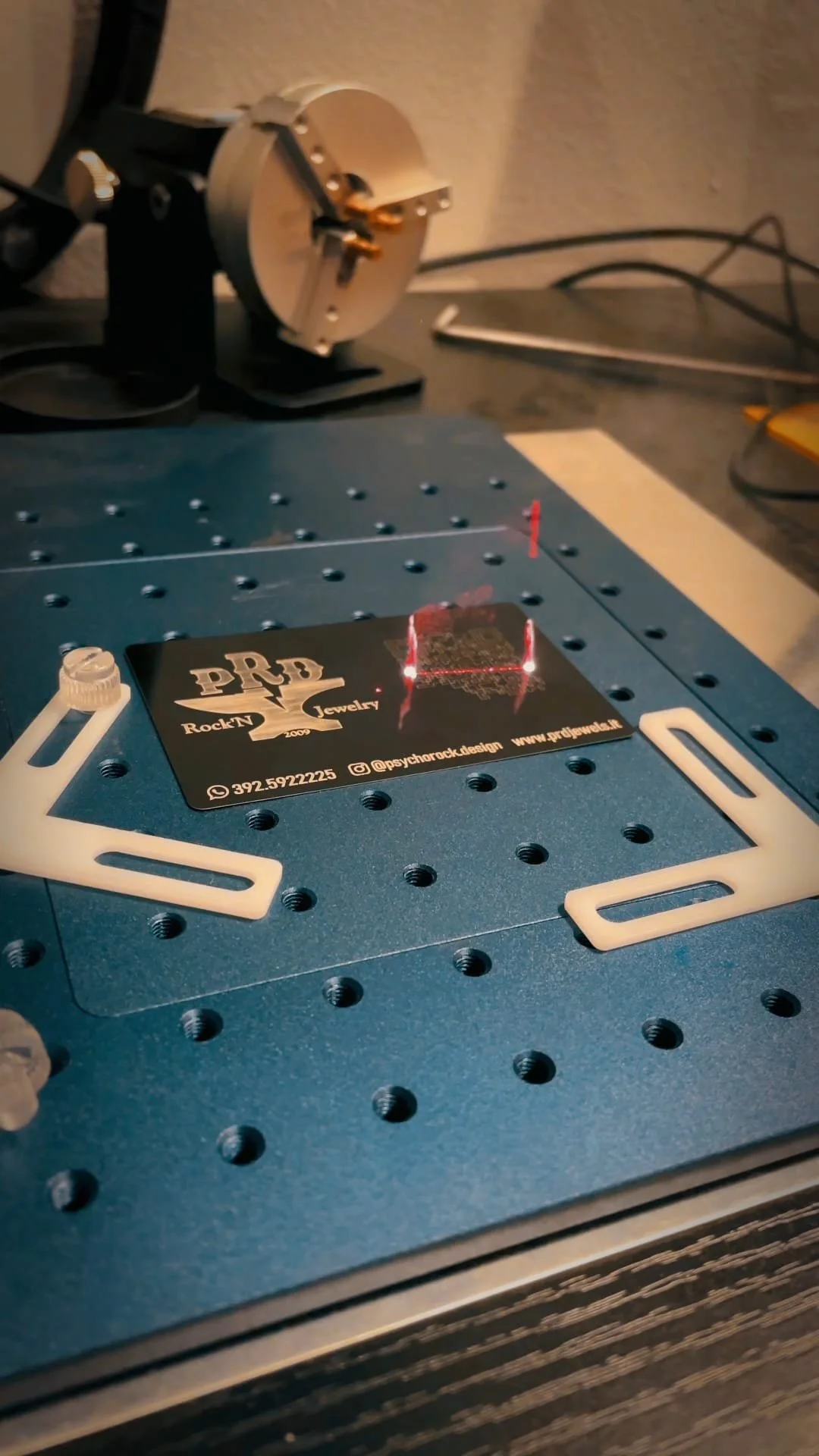 Edificio moderno in legno con grandi finestre, situato in un paesaggio montano con vegetazione secca e alte montagne sullo sfondo.