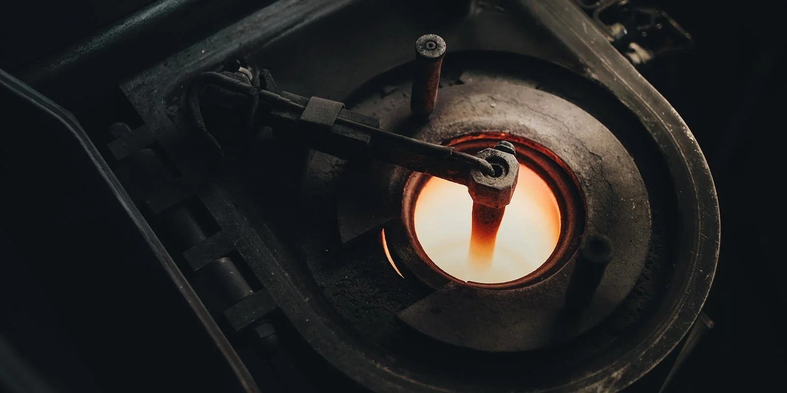 Paesaggio montano con montagne con neve sullo sfondo e una piccola costruzione moderna su una collina erbosa in primo piano.