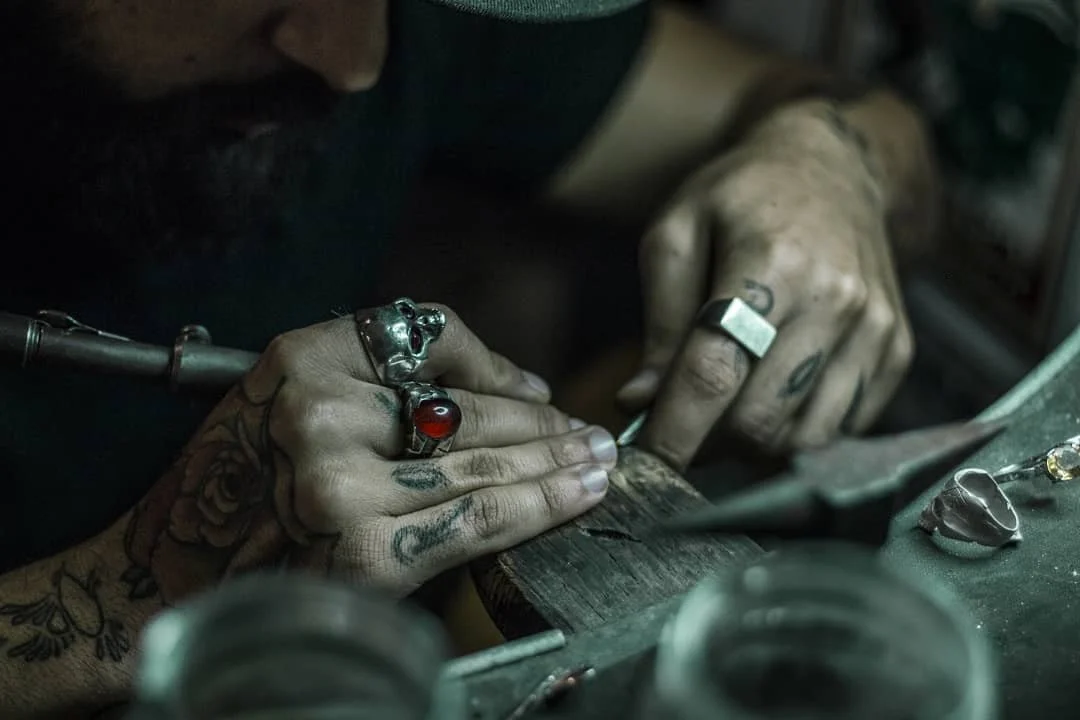 Casa moderna in legno con terrazza e scale in pietra, circondata da vegetazione e con montagne innevate sullo sfondo.