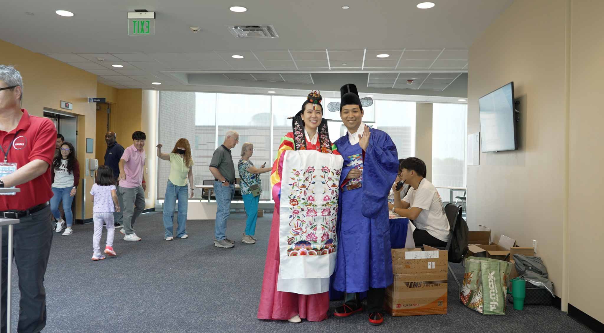 People in traditional Korean clothing posing for photos in an indoor setting
