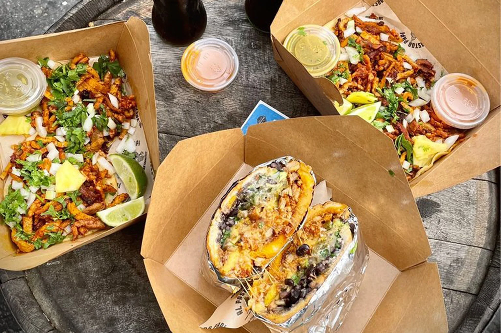 Dishes from Al Pastor Papi: Tacos and a burrito with various sauces