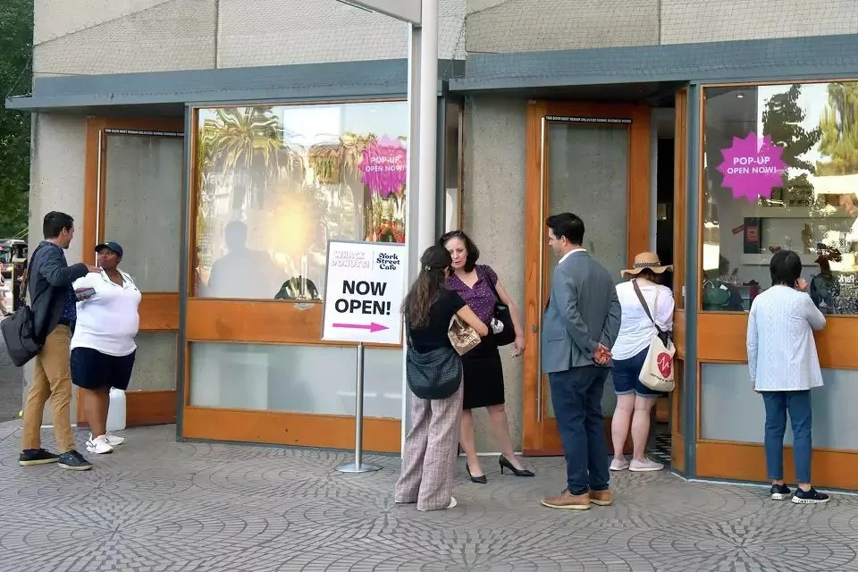 People standing at the exterior of the new Whack Donuts Vacant to Vibrant pop-up at Four Embarcadero Center, Friday, Oct. 6, 2023.